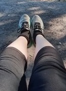 A closeup of two legs with running shoes, socks, and shorts on them.