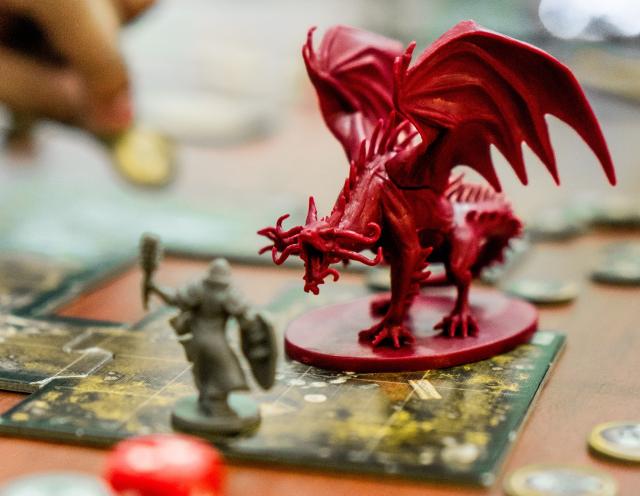 A Dungeons and Dragons scene with a grey plastic knight battling a big red dragon.
