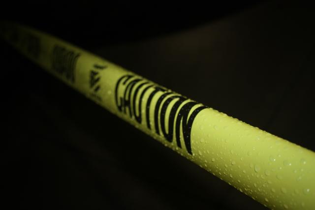 Police hazard barrier tape. It is yellow with 'caution' written on it in black.