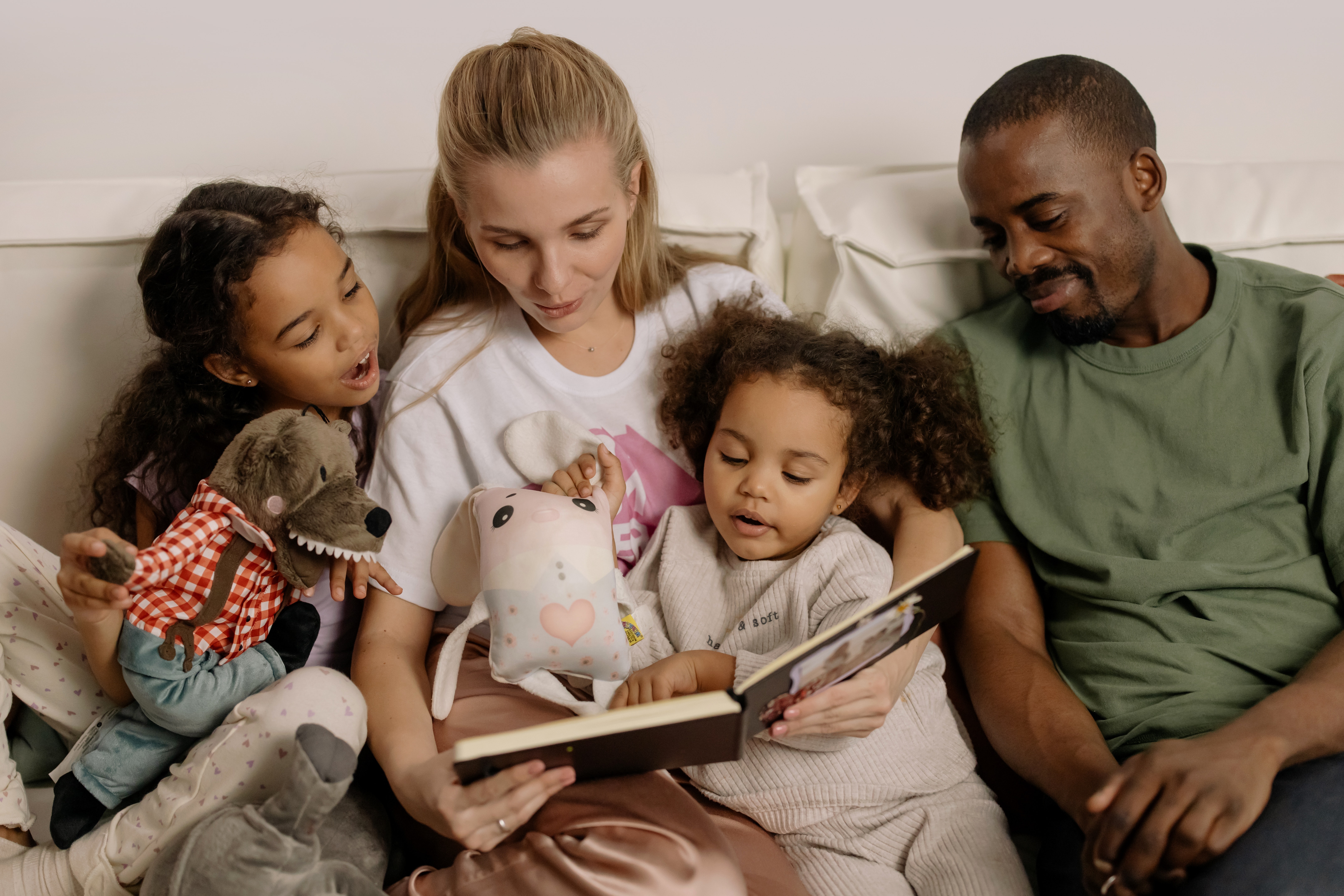 Parents and two children reading a book together