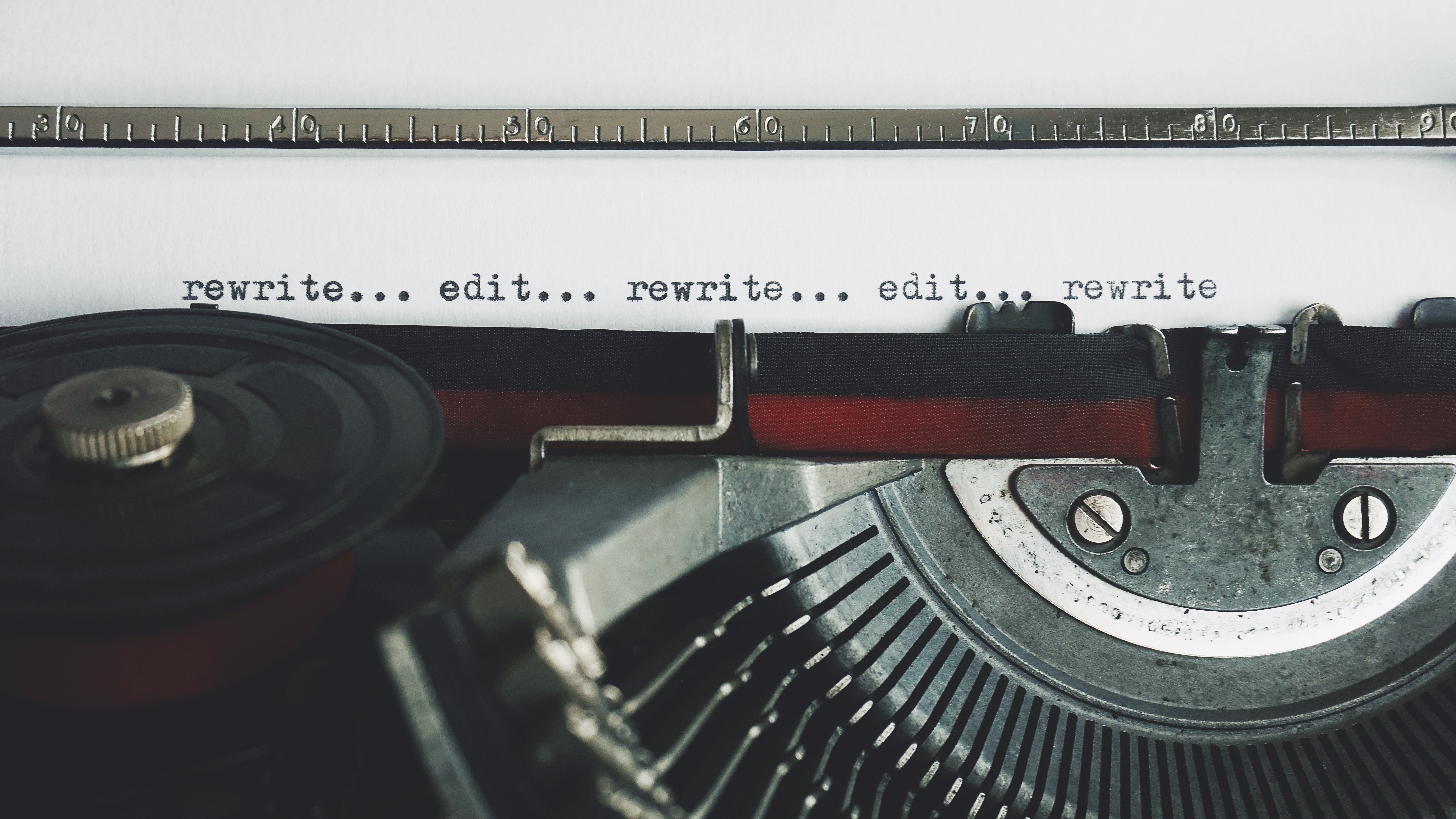 Typewriter typing the text "rewrite... edit... rewrite... edit... rewrite"