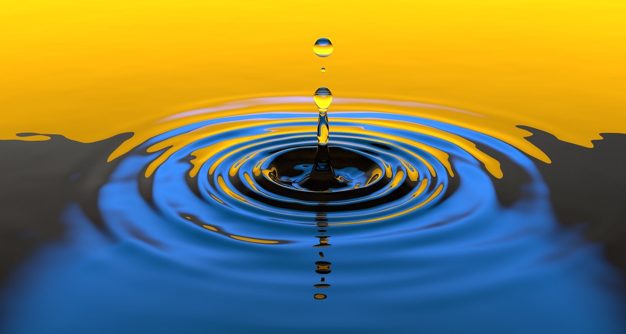 Photo of a water droplet creating ripples on a lake