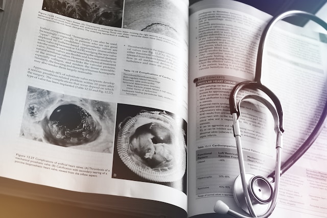 a medical journal is open on a desk with a stethoscope to one side