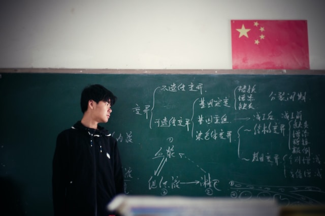 A teacher stands in front of a blackboard in a Chinese school 