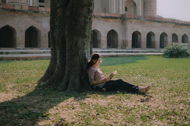 woman reading under a tree