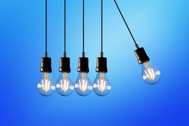 four lightbulbs together and one on its own, about to swing towards the others
